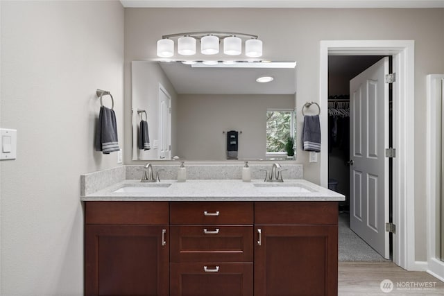 6579 Gleneagle Ave SW, Port Orchard, WA 98367 - bathroom featuring double vanity, wood finished floors, and a walk in closet