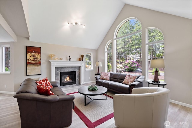 6579 Gleneagle Ave SW, Port Orchard, WA 98367 - living room with a fireplace, high vaulted ceiling, baseboards, and light wood-style flooring