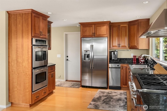 4906 157th Ave SE, Bellevue, WA 98006 - kitchen featuring stainless steel appliances, wall chimney exhaust hood, a sink, light wood-style floors, and recessed lighting