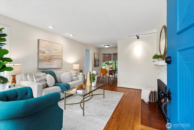 14817 Fremont Ave N, Shoreline, WA 98133 - living room featuring a fireplace with flush hearth, recessed lighting, wood finished floors, a textured ceiling, and baseboards