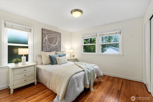 14817 Fremont Ave N, Shoreline, WA 98133 - bedroom with baseboards, wood finished floors, a textured ceiling, and a closet