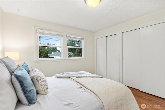 14817 Fremont Ave N, Shoreline, WA 98133 - bedroom featuring multiple closets, wood finished floors, and a textured ceiling
