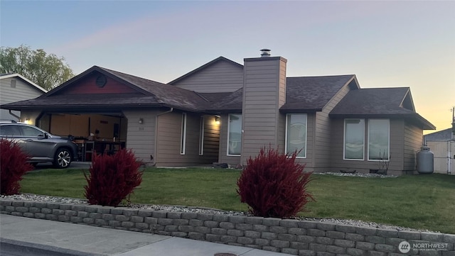 319 N Grape Dr, Moses Lake, WA 98837 - view of front of property featuring a chimney, a lawn, an attached garage, and a shingled roof