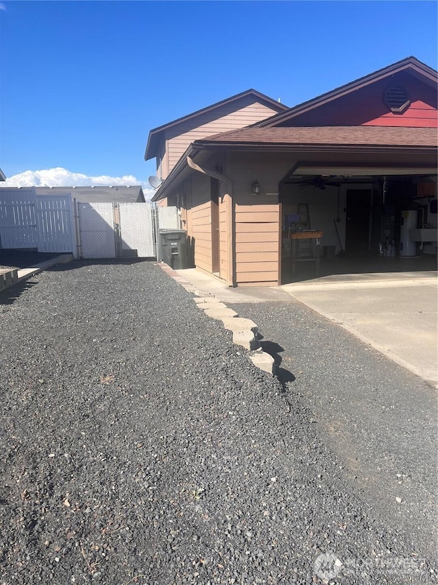 319 N Grape Dr, Moses Lake, WA 98837 - view of home's exterior with driveway, water heater, and a gate