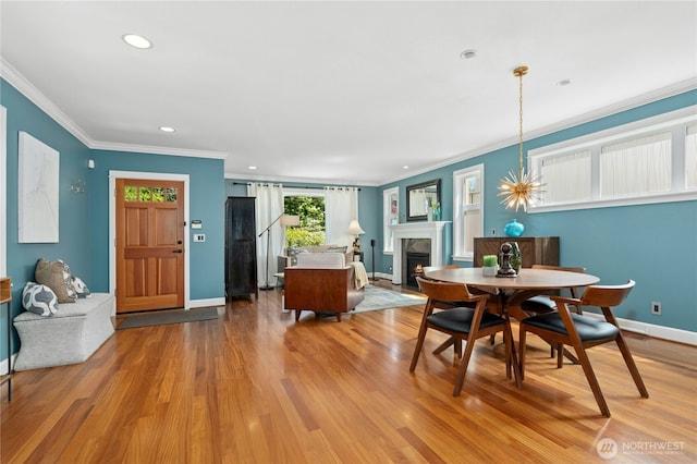 1109 30th Ave S, Seattle, WA 98144 - dining space with a lit fireplace, wood finished floors, ornamental molding, baseboards, and recessed lighting