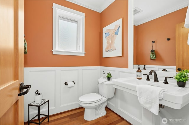 1109 30th Ave S, Seattle, WA 98144 - bathroom featuring toilet, ornamental molding, a wainscoted wall, wood finished floors, and a decorative wall