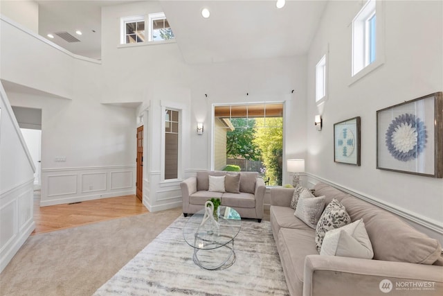 7301 NE 155th St, Kenmore, WA 98028 - living area with carpet floors, healthy amount of natural light, a towering ceiling, wainscoting, and recessed lighting