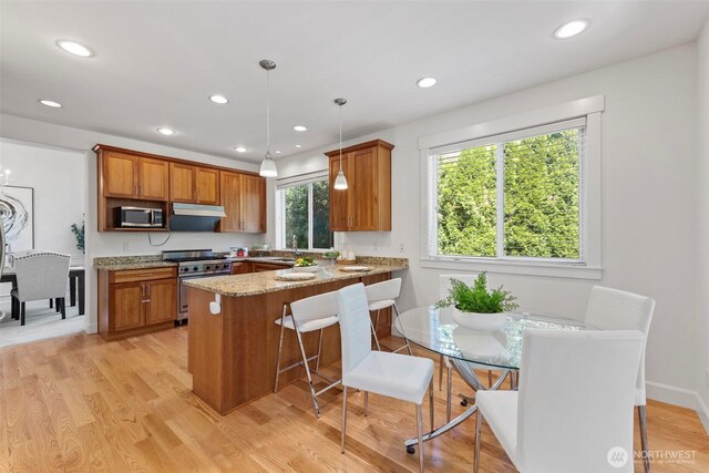 7301 NE 155th St, Kenmore, WA 98028 - kitchen with stainless steel appliances, brown cabinetry, a peninsula, recessed lighting, and light stone countertops
