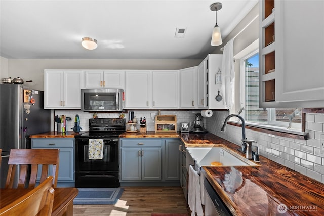 10096 Terra Glenn St SE, Yelm, WA 98597 - kitchen featuring black electric range, wood counters, stainless steel microwave, and decorative backsplash