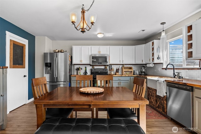 10096 Terra Glenn St SE, Yelm, WA 98597 - kitchen with stainless steel appliances, wood finished floors, backsplash, and a chandelier