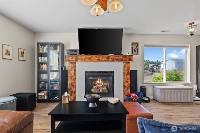 10096 Terra Glenn St SE, Yelm, WA 98597 - living room with wood finished floors, a chandelier, and a fireplace