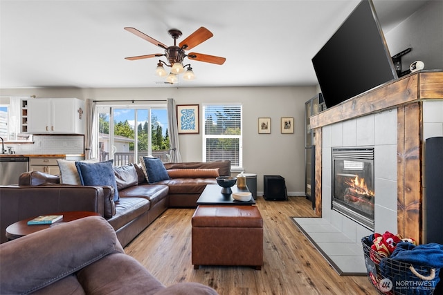 10096 Terra Glenn St SE, Yelm, WA 98597 - living room with light wood-style flooring, ceiling fan, a fireplace, and baseboards