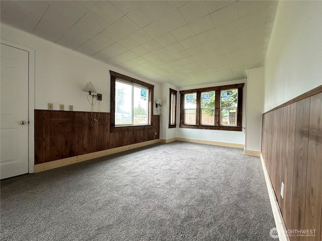381 Trillium Ave, Forks, WA 98331 - carpeted empty room with wood walls and a wainscoted wall