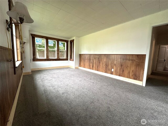 381 Trillium Ave, Forks, WA 98331 - carpeted spare room with wood walls and a wainscoted wall