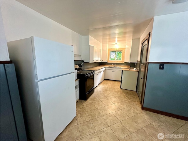 381 Trillium Ave, Forks, WA 98331 - kitchen featuring freestanding refrigerator, black range with electric stovetop, white cabinetry, and light tile patterned flooring