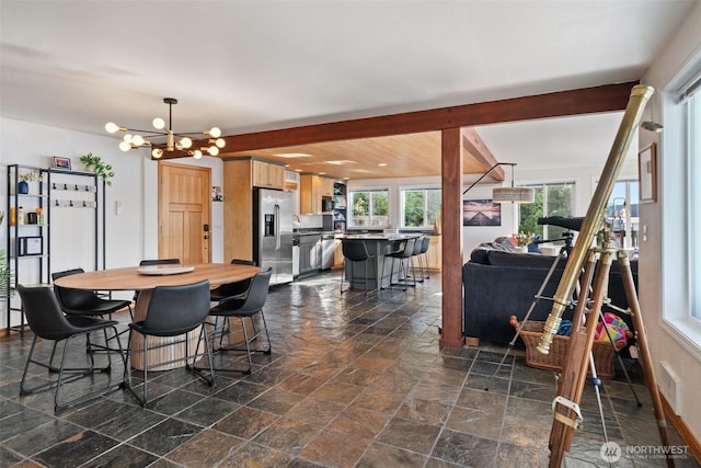 9451 E State Route 106, Union, WA 98592 - dining room featuring stone tile flooring, beam ceiling, and a chandelier