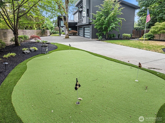 7708 Walnut St SW, Lakewood, WA 98498 - surrounding community with a putting green, an attached garage, and driveway