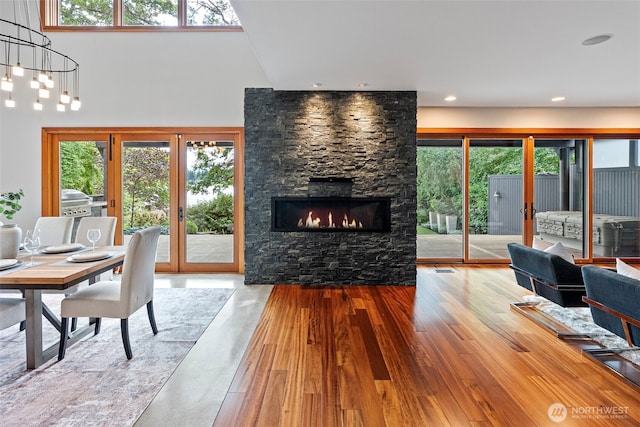 7708 Walnut St SW, Lakewood, WA 98498 - dining area with french doors, a stone fireplace, a high ceiling, and wood finished floors