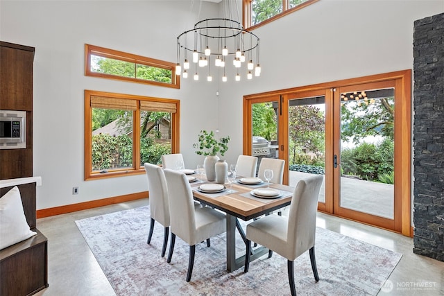 7708 Walnut St SW, Lakewood, WA 98498 - dining room featuring a high ceiling, french doors, concrete floors, and a chandelier