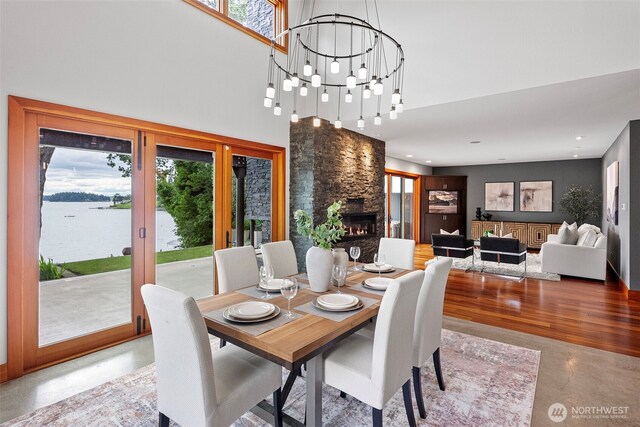 7708 Walnut St SW, Lakewood, WA 98498 - dining area featuring a towering ceiling, a fireplace, a chandelier, recessed lighting, and a water view