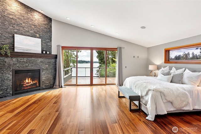 7708 Walnut St SW, Lakewood, WA 98498 - bedroom featuring lofted ceiling, access to exterior, wood finished floors, a fireplace, and a water view