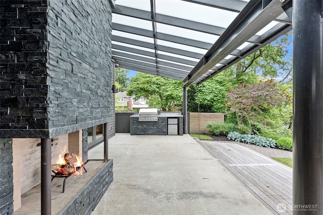 7708 Walnut St SW, Lakewood, WA 98498 - view of patio featuring an outdoor stone fireplace and exterior kitchen