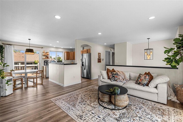 1324 Fairhaven Ave, Wenatchee, WA 98801 - living area featuring dark wood-style flooring, a chandelier, recessed lighting, arched walkways, and baseboards