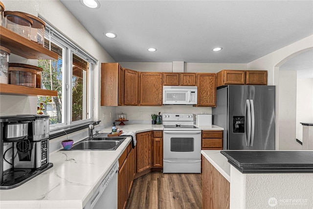 1324 Fairhaven Ave, Wenatchee, WA 98801 - kitchen with white appliances, a sink, dark wood-style floors, brown cabinetry, and arched walkways