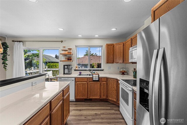 1324 Fairhaven Ave, Wenatchee, WA 98801 - kitchen featuring white appliances, healthy amount of natural light, brown cabinetry, and recessed lighting