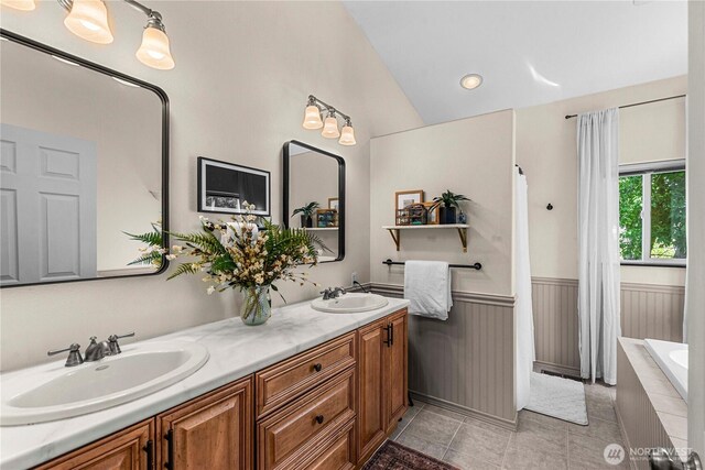 1324 Fairhaven Ave, Wenatchee, WA 98801 - bathroom with double vanity, tiled tub, lofted ceiling, wainscoting, and tile patterned floors
