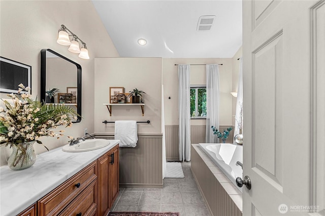 1324 Fairhaven Ave, Wenatchee, WA 98801 - full bath featuring vanity, a garden tub, lofted ceiling, a wainscoted wall, and tile patterned flooring