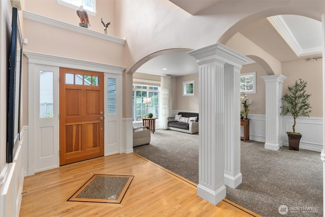 13327 SE 279th Pl, Kent, WA 98042 - carpeted foyer entrance featuring ornate columns, wainscoting, arched walkways, a decorative wall, and wood finished floors