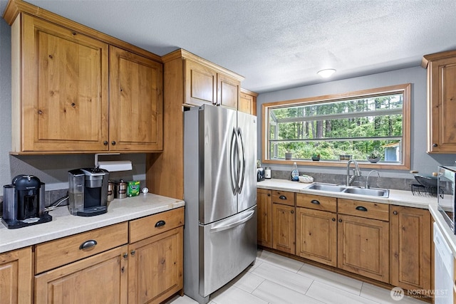 15412 SE 304th Pl, Kent, WA 98042 - kitchen featuring freestanding refrigerator, a sink, brown cabinetry, light countertops, and a textured ceiling