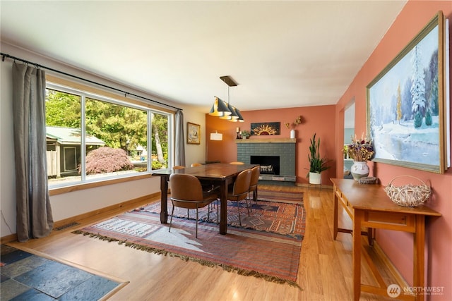 26933 NE Cherry St, Duvall, WA 98019 - dining space with wood finished floors, a fireplace with raised hearth, and baseboards