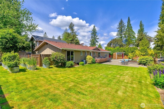 26933 NE Cherry St, Duvall, WA 98019 - back of property with board and batten siding, a wooden deck, a garden, cooling unit, and a patio