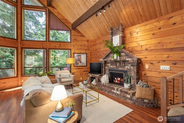 7755 NE Seawind Ave, Poulsbo, WA 98370 - living room featuring track lighting, wooden ceiling, wood finished floors, a brick fireplace, and wood walls