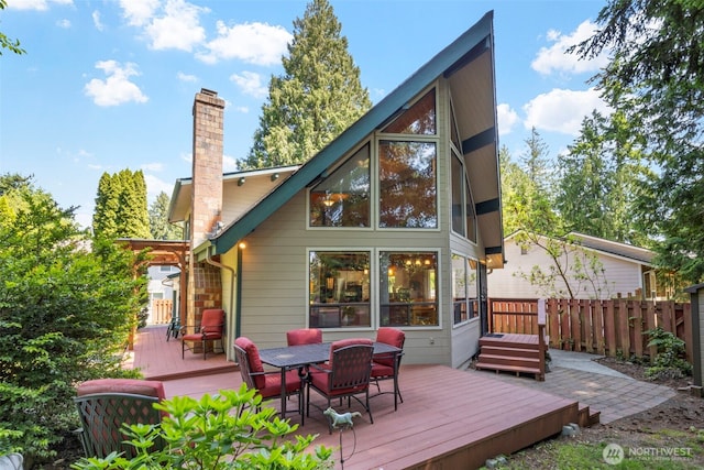 7755 NE Seawind Ave, Poulsbo, WA 98370 - back of house featuring a chimney, a wooden deck, and outdoor dining area