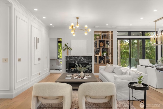7116 NE 119th Ln, Kirkland, WA 98034 - living room featuring a chandelier, healthy amount of natural light, light wood-style flooring, crown molding, and recessed lighting