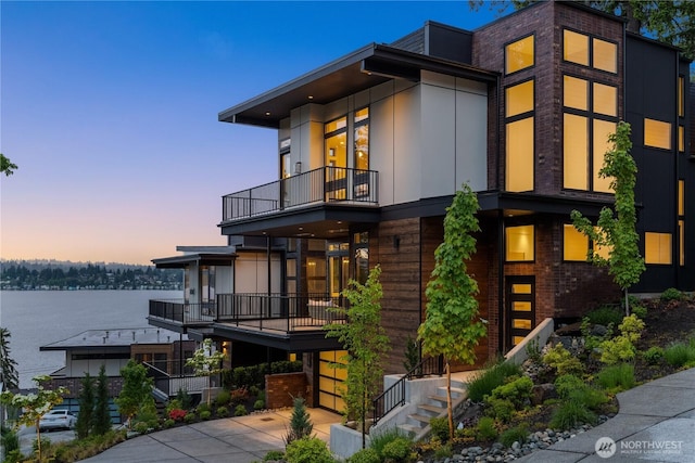 7116 NE 119th Ln, Kirkland, WA 98034 - modern home with a balcony, a water view, and concrete driveway