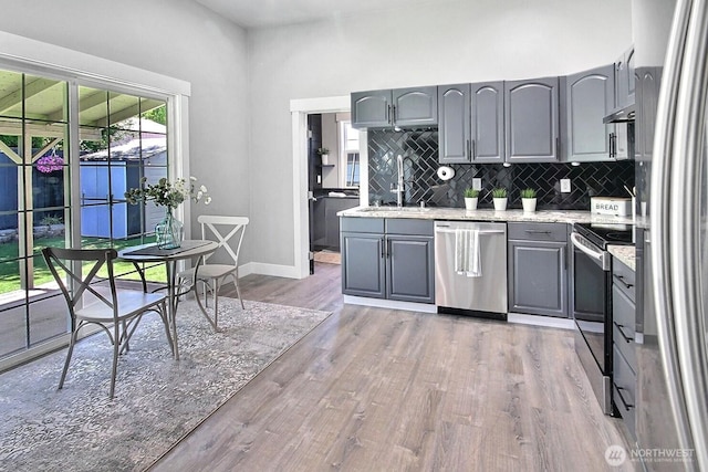 1630 Hillcrest Ave, Enumclaw, WA 98022 - kitchen with appliances with stainless steel finishes, gray cabinets, a sink, decorative backsplash, and light wood finished floors