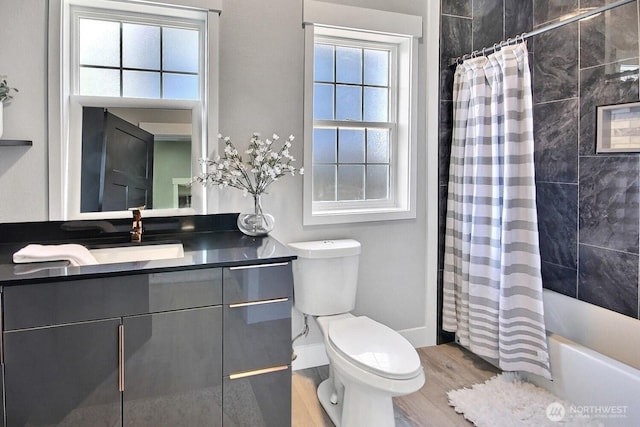 1630 Hillcrest Ave, Enumclaw, WA 98022 - full bath featuring wood finished floors, toilet, vanity, shower / bathtub combination with curtain, and baseboards