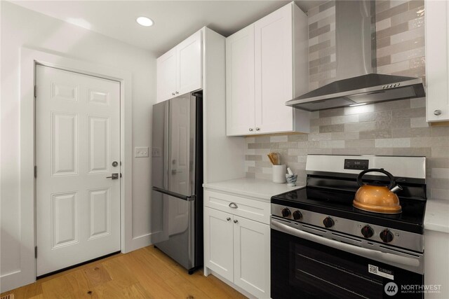 2614 E Olive St, Seattle, WA 98122 - kitchen featuring appliances with stainless steel finishes, wall chimney range hood, white cabinets, and recessed lighting