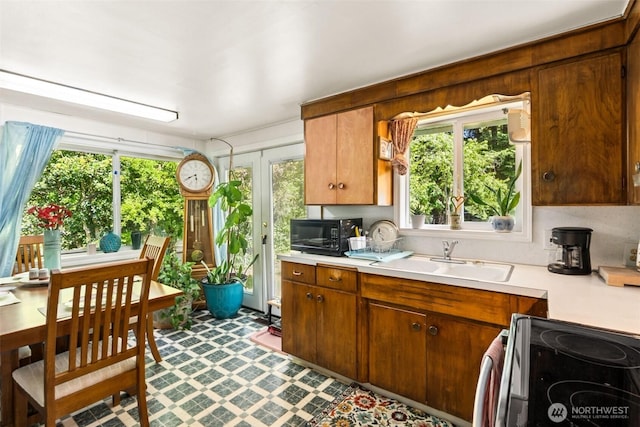 221 NW Nichols Ave, Bremerton, WA 98311 - kitchen featuring black microwave, a sink, light countertops, and stainless steel electric range