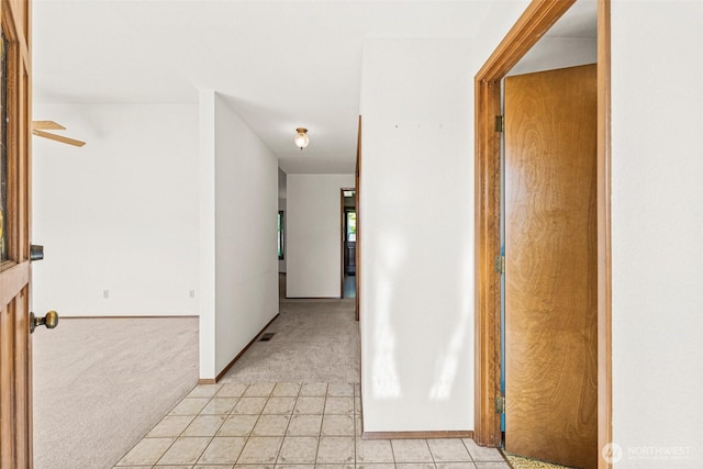 6410 151st Ave E, Sumner, WA 98390 - hallway featuring light colored carpet, light tile patterned floors, and baseboards