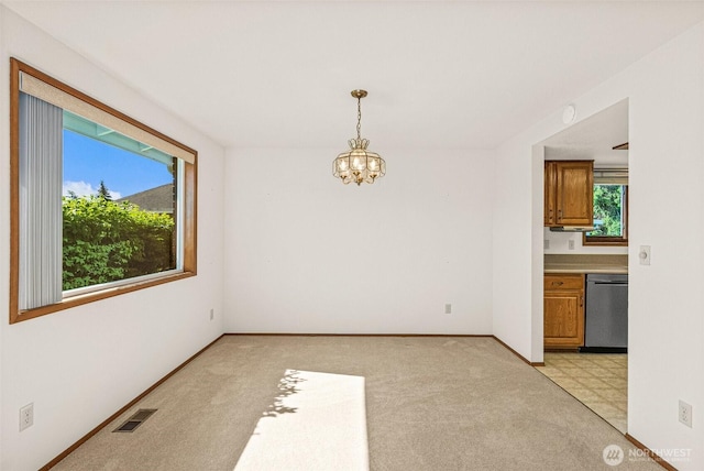 6410 151st Ave E, Sumner, WA 98390 - unfurnished dining area featuring a chandelier, plenty of natural light, baseboards, and light carpet