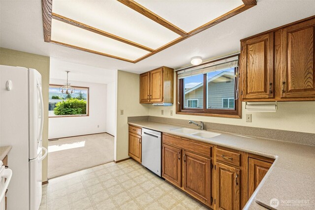 6410 151st Ave E, Sumner, WA 98390 - kitchen with dishwasher, freestanding refrigerator, a sink, light floors, and brown cabinets