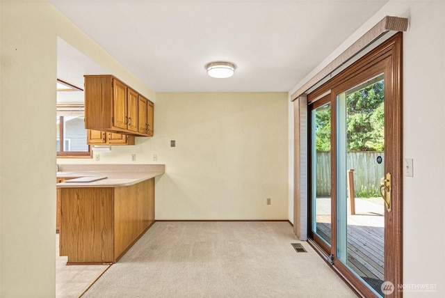 6410 151st Ave E, Sumner, WA 98390 - kitchen featuring light countertops, brown cabinets, baseboards, and light carpet