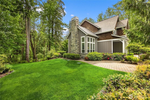 3029 Yankee Girl Cir NE, Bainbridge Island, WA 98110 - rear view of property featuring a chimney, board and batten siding, roof with shingles, a yard, and stone siding