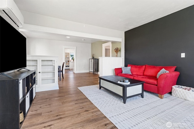 1102 Tecumseh St, Aberdeen, WA 98520 - living room with a wall mounted air conditioner, wood finished floors, and baseboards