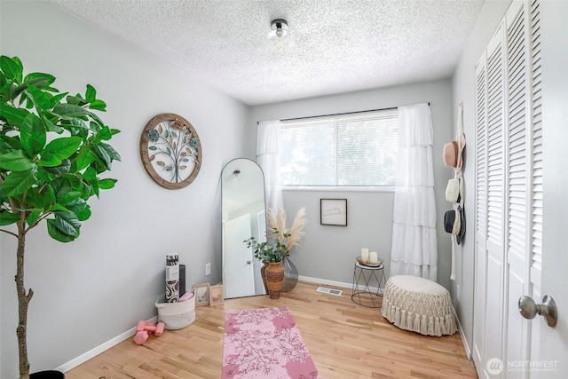 5907 N 31st St, Tacoma, WA 98407 - living area with wood finished floors, a textured ceiling, and baseboards